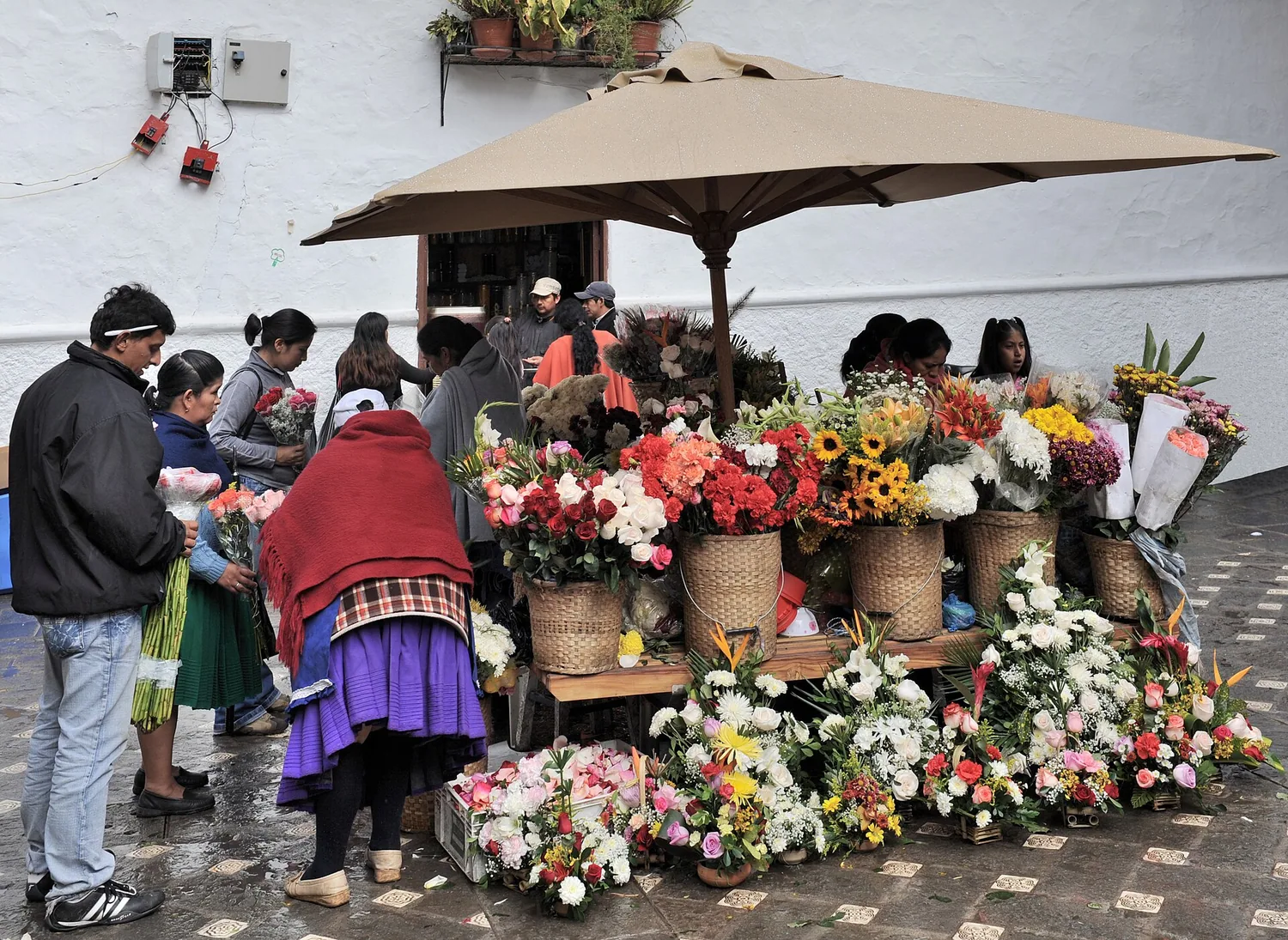 Vendedoras y arreglos florales en la tradicional Plaza de las Flores de Cuenca